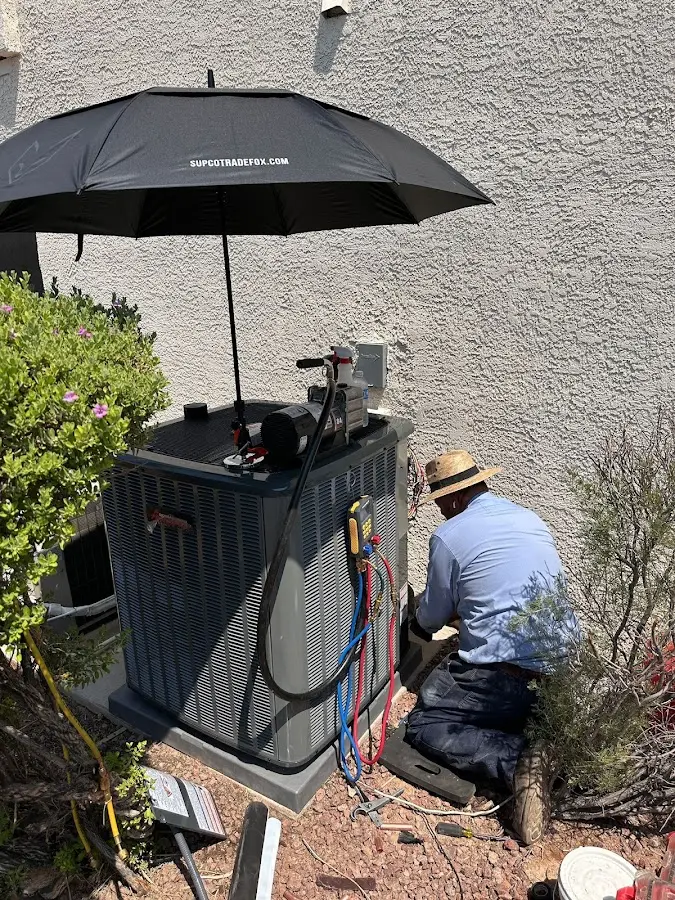 HVAC technician performing outdoor AC maintenance in Cottonwood