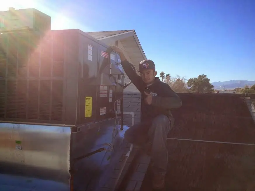HVAC technician performing Air Duct Repair on a rooftop unit in Cottonwood